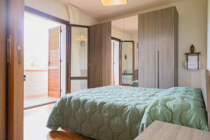 a bedroom with a green bed and a large window at La casa di Tilde in Vicchio +29 photos