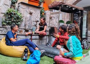 un grupo de personas sentadas en la hierba en Pariwana Hostel Cusco, en Cusco