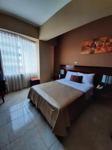 a bedroom with a large bed and a large window at Gran Hotel Ica in Ica