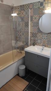 a bathroom with a sink and a tub and a mirror at Les châlets de Renoir 1 in La Roche-Posay