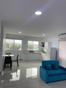 a living room with a blue couch and a kitchen at Apto #18 con Hermosa Vista piso 3 in Machala +8 photos