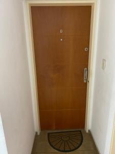 eine Holztür in einem Flur mit einer Matte davor in der Unterkunft Depto Plaza Belgrano 14 Y 38 in La Plata