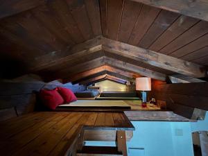 a room with a bed and a table with a lamp at La Mansarda di Laura a Danta in Danta