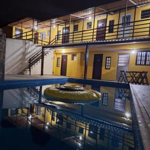 a building with a pool of water in front of a building at Pousada da Lorena in Itanhaém