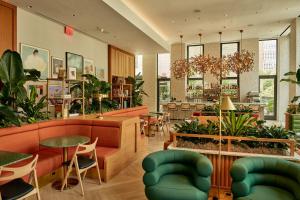a restaurant with tables and chairs and plants at Park Terrace Hotel in New York