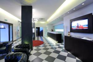 a lobby with a tv and a checkered floor at Hotel La Torretta in Bollate