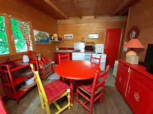 a kitchen with a red table and red chairs at B&B L'Albatros in Fayence