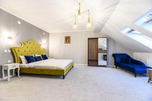 a bedroom with a yellow bed and a blue chair at Dallure House Boutique Brasov in Braşov