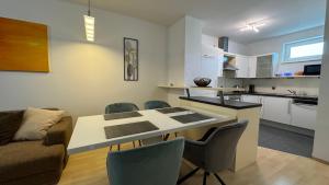 a kitchen and living room with a table and chairs at City Apartment Linz 3 Zimmer - Klimaanlage, Großes Sofa, Cafe & WLAN, Selfcheckin, Parkplatz, für 5 Gäste in Linz