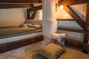 a room with two beds and a bench in it at Rustikálna chalúpka pri jazere in Ľuborča