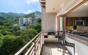 a balcony with a kitchen and a view of a city at Pinnacle Resorts at Zona Romantica in Puerto Vallarta