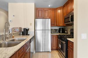 een roestvrijstalen koelkast in een keuken met houten kasten bij Lakeview Condo - Lakefront Complex, Lake Views, Heated Pool in Big Bear Lake