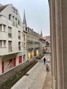 a person walking down a street next to a building at Mulhouse hyper centre - Grand T3- Aux bons enfants in Mulhouse