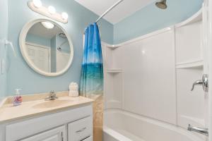 Un baño con bañera, lavabo y espejo. en The 19th Hole -5 Bdr Slps 10 Golf Beach Pool Heat Hot Tub Extended Stay Welcome!!, en Myrtle Beach 13 fotos más