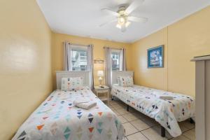 Un dormitorio con dos camas y un ventilador de techo. en The 19th Hole -5 Bdr Slps 10 Golf Beach Pool Heat Hot Tub Extended Stay Welcome!!, en Myrtle Beach