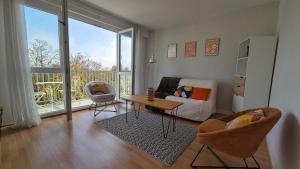 Una sala de estar con una cama, una mesa y sillas. en Appartement Clara Parking Gratuit, en Mont-Saint-Aignan