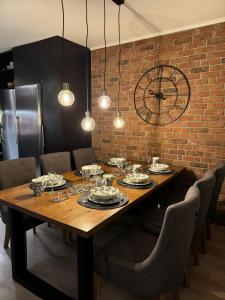 a dining room table with chairs and a large clock at Lapland Cozy Apartment in Rovaniemi