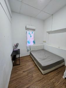 a white room with a bed and a table at Amoy Lane Hostel Penang in George Town