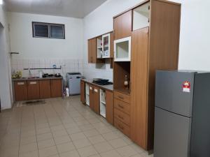 a kitchen with wooden cabinets and a refrigerator at Amoy Lane Hostel Penang in George Town