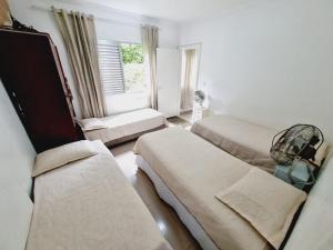 ein Krankenzimmer mit zwei Betten und einem Fenster in der Unterkunft Edifício Plaza de Saint Martin in Santos