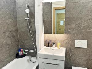 a bathroom with a sink and a mirror and a tub at Alpin-schick, 39m2, Ski & Sport, mit Pool - SK213 in St. Moritz