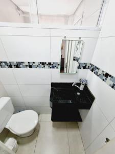 ein Bad mit einem schwarzen Waschbecken und einem WC in der Unterkunft Edifício Plaza de Saint Martin in Santos + 35 Fotos