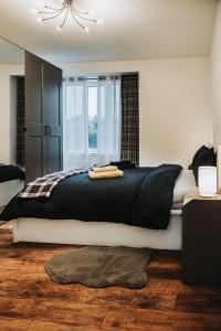 ein Schlafzimmer mit einem großen Bett mit schwarzer Bettwäsche und einem Fenster in der Unterkunft Large bedroom, close to Airport and City Centre in Edinburgh