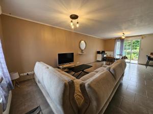 a living room with a couch and a tv at Grande maison proche de Chambord et de la Loire in Saint Laurent Nouan