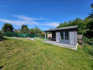 a small shed on a lawn in a yard at Grande maison proche de Chambord et de la Loire in Saint Laurent Nouan