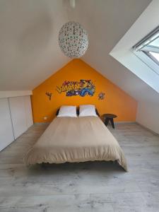 a bedroom with a large bed with an orange wall at Grande maison proche de Chambord et de la Loire in Saint Laurent Nouan