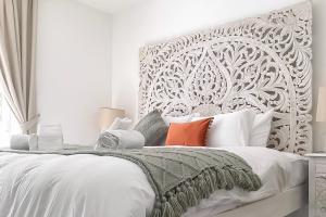 a white bedroom with a large white bed with pillows at Modern Beautiful Pool And Sea Apt Qawra - Happy Rentals in Qawra