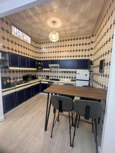 kuchnia z niebieskimi szafkami i drewnianym stołem i krzesłami w obiekcie Relax Apartment - private Jacuzzi/SPA with 2bedrooms (A/C) - Netflix - 24 h/entry w Maladze