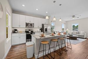 a kitchen with white cabinets and a large island with bar stools at Open w Water & Power- 10 min to Asheville! in Asheville