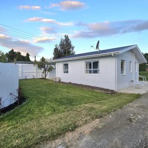 una casa bianca con cortile di Pasture Views Cottage a Riwaka