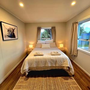 una camera da letto con un letto con due asciugamani sopra di Pasture Views Cottage a Riwaka