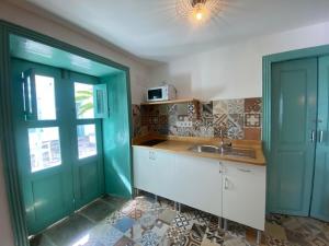 a kitchen with blue doors and a sink in a room at Hacienda de las Indias, Camagüey in Granadilla de Abona