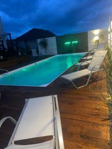 Una piscina de noche con sillas alrededor. en Las Totoras 2, en Punta del Diablo