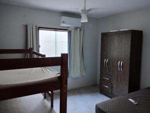 a bedroom with a bunk bed and a dresser and a window at Casa em Piuma proximo a praia in Piúma