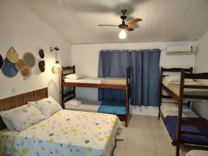 a bedroom with two bunk beds and a ceiling at Villa Bali Maresias Lofts in Maresias