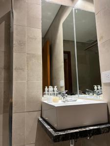 a bathroom with a sink and a mirror at Atalaya Suites - Salta in Salta