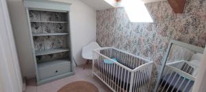 a baby room with a crib and a wall at "Le petit Breizh 2" entre Mt St Michel et Saint Malo 6personnes 1bébé in Saint-Marcan +12 photos