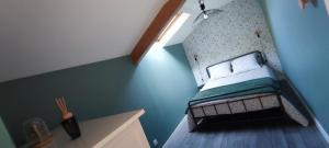 a small bedroom with a bed in a blue wall at "Le petit Breizh 2" entre Mt St Michel et Saint Malo 6personnes 1bébé in Saint-Marcan +17 photos