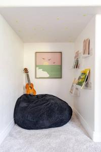 a room with a large bean bag chair and a guitar at Beacons Beach Cottage in Encinitas