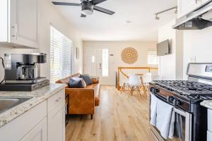 a kitchen with a stove top oven next to a living room at Beacons Beach Cottage in Encinitas