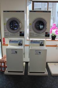 a room with three washing machines in a room at HOTEL LiVEMAX Mihara Ekimae in Mihara