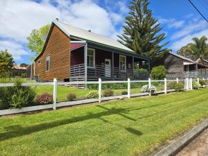 a house with a fence in front of a yard at Millhouse on Pine in Pemberton
