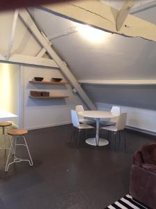 ein Zimmer mit einem Tisch und Stühlen im Dachgeschoss in der Unterkunft Vakantie Appartement De Sneppelhoeve in Wuustwezel