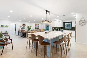 a kitchen and living room with a large island with stools at Walking from the beach 3Br Villa in Fort Lauderdale