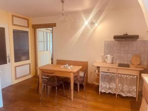a kitchen with a wooden table and a dining room at Petit appartement au rez in Baulmes