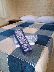 a blue and white bed with pillows on it at Flats Mundos Pipa in Pipa